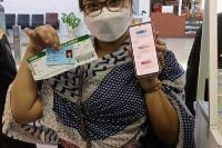 Seorang pengguna jasa penerbangan di BIM menunjukkan dua hasil vaksinasinya saat ingin berangkat melalui BIM, Selasa siang (8/3). (Istimewa)