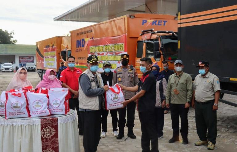 Bupati Pasbar, Hamsuardi saat menerima bantuan Presiden RI, yang diserahkan Sespri Presiden, Untoro di Pasbar, Selasa sore (1/3). (Dok : Istimewa)