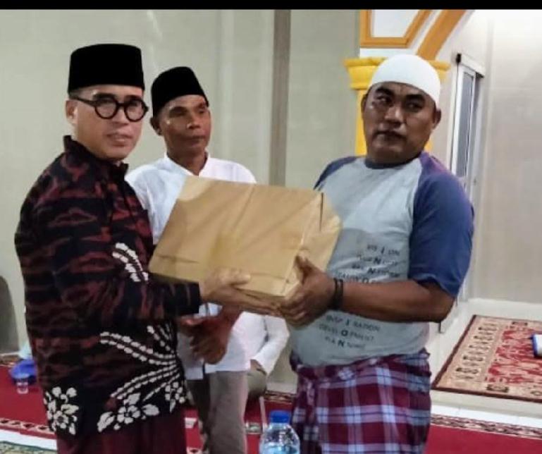 Anggota DPD RI, Alirman Sori saat serahkan bantuan kepada salah seorang pengurus masjid yang ada di Pessel, saat lakukan Safari Ramadan, Minggu malam (24/4). (Dok : Istimewa)