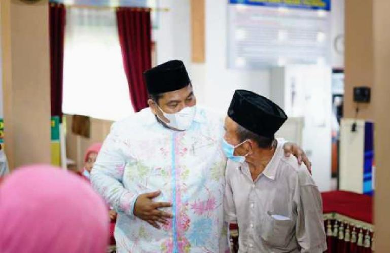 Bupati Suhatri Bur bersama salah seorang warga penerima dana desa di Nagari Pilubang, Sungai Limau, Sabtu (30/4). (Dok : Istimewa)