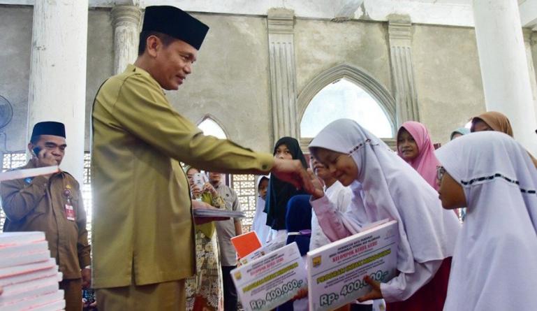 Wako Genius Umar saat menyerahkan infak mingguan PTK kepada anak SD se Kecamatan Pariaman Timur, Selasa (19/4). (Dok : Istimewa)