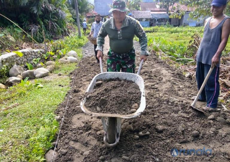 Babinsa Koramil 06/KTN, Kodim 312/Padang, Pelda Afrizal sedang bantu warga bangun jalan rabat beton, Kamis (28/4). (Foto : Derizon)