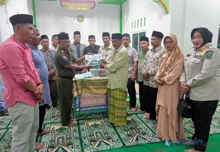 Plt Kasat Pol PP dan Pemadam Kebakaran Padangpariaman, Marsidi serahkan secara simbolis bantuan pemkab kepada pengurus Surau Rimbo Kaduduak, Kamis malam (7/4). (Foto : Arzil)