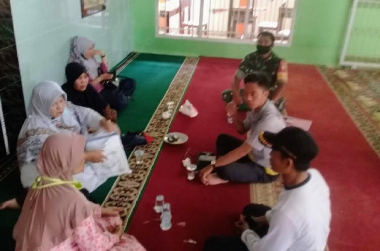 Babinsa Kelurahan Tabiang Banda Gadang, Serda Sunarto bersama perangkat kelurahan diskusikan keamanan perumahan setempat saat mudik Lebaran. (Dok : Istimewa)