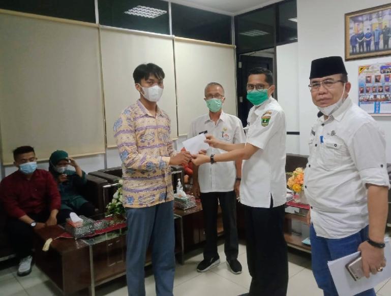 Sekretaris DPRD Sumbar, Raflis memberikan santunan kepada salah seorang anak yatim, Rabu (20/4). (Dok : Istimewa)