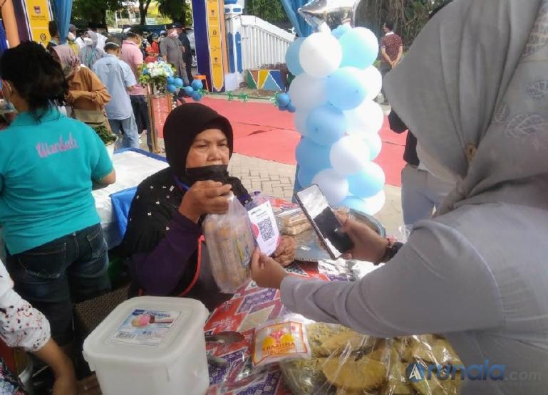 Pedagang dan pembeli di Pasa Pabukoan sedang bertransaksi menggunakan QRIS, Senin (4/4). (Foto : Derizon)
