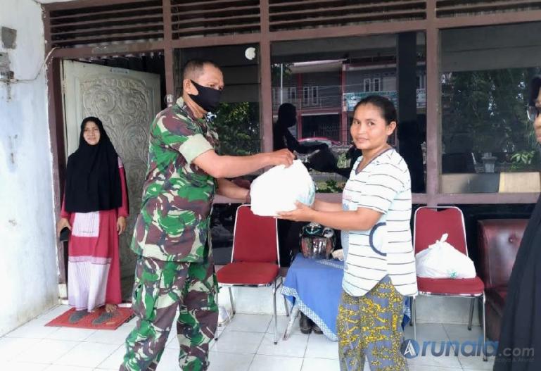 Anggota Babinsa Kelurahan Kurao Pagang, Serda Jafriadi serahkan bantuan sembako pada warga kurang mampu, Sabtu (14/5). (Foto : Derizon)