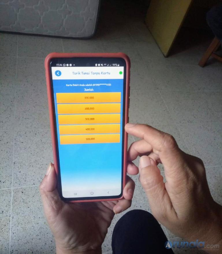 Nasabah Bank Nagari memperlihatkan fitur tarik tunai tanpa kartu di Nagari Mobile Banking. (Foto : Fajril)