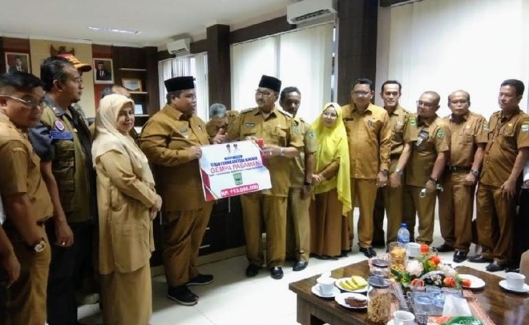 Bupati Suhatri Bur saat serahkan bantuan korban gempa kepada Bupati Pasaman, Benny Utama, Selasa (24/5). (Dok : Istimewa)