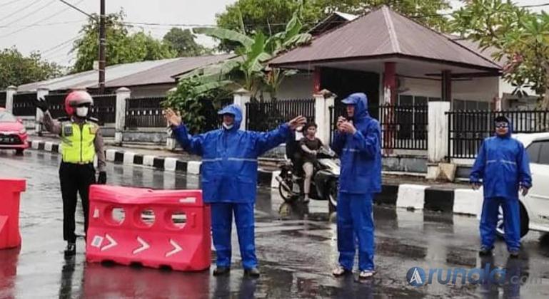Personel Satlantas Polres Pariaman dan Petugas Dinas Perhubungan diguyur hujan yang sedang mengatur lalu lintas menuju objek wisata di kota itu, Sabtu (7/5). (Dok : Istimewa)
