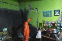 Personel BPBD Kabupaten Mamuju, Sulawesi Tengah melihat retakan rumah warga yang kena gempabumi 5.8 M di daerah itu, Rabu (8/6). (Dok : Istimewa)