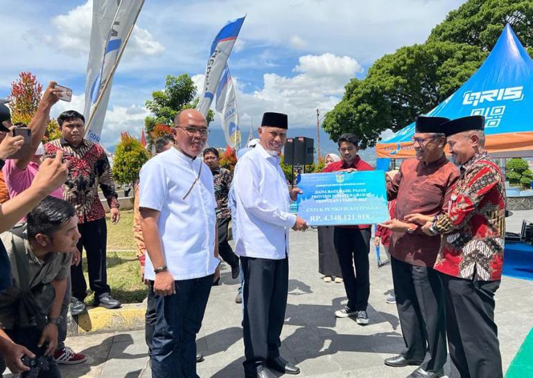 Ketua DPRD Sumbar, Supardi saksikan Gubernur Mahyeldi serahkan pajak bagi hasil pada salah seorang kepala daerah di Bukittinggi, (Dok : Istimewa)