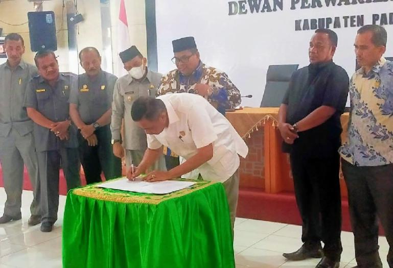 Bupati Padangpariaman Suhatri Bur menyaksikan Ketua DPRD Arwinsyah, menandatangani nota pengesahan Perda LKPJ APBD 2021, Selasa (14/6). (Dok : Istimewa)