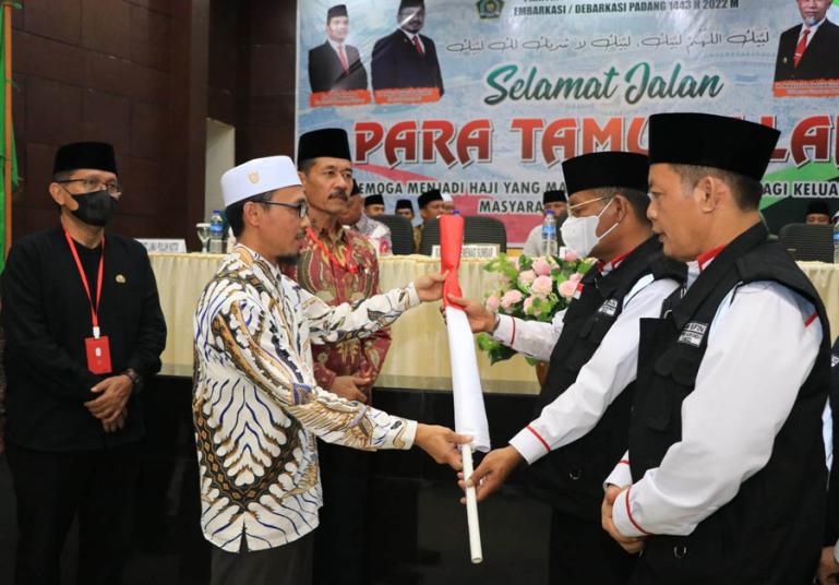 Wakil Ketua DPRD Sumbar, Irsyad Syafar serahan bendera kepada ketua kloter III, Zulkarnain Batubara saat acara pelepasan kloter tersebut, Minggu malam (5/6). (Dok : Istimewa)