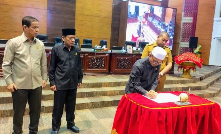 Wakil ketua DPRD Sumbar, Irsyad Safar disaksikan Wagub Audy Joinaldy saat tanda tangani berita acara pengesahan Perda KIP seusai rapat paripurna, Senin (19/7). (Dok : Istimewa)