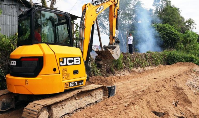 Sebuah alat berat sedang meratakan bagian badan jalan yang dibuka secara swadaya oleh Pemko Pariaman, Rabu (6/7). (Dok : Istimewa)