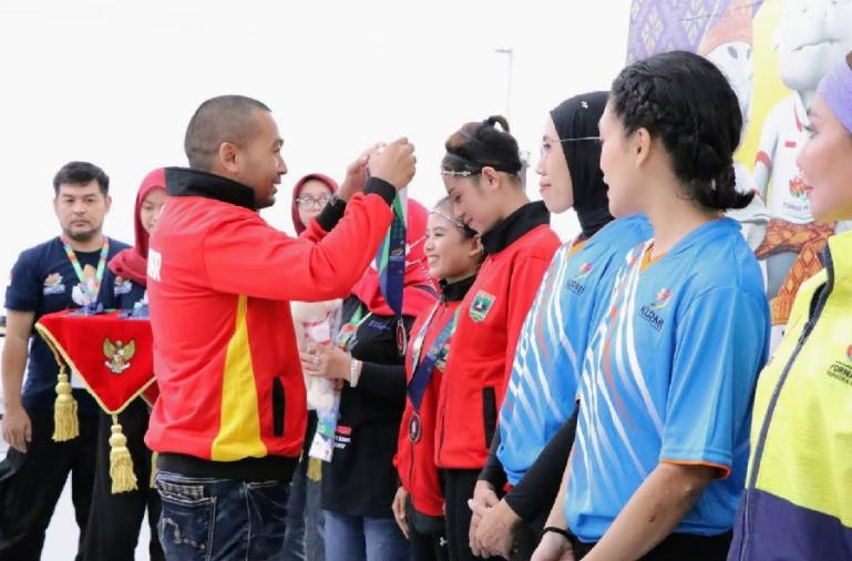 Wagub Audy kalungkan medali pada atlet Sumbar yang berprestasi di ajang Fornas VI Palembang, Sabtu (2/7). (Dok : Istimewa)