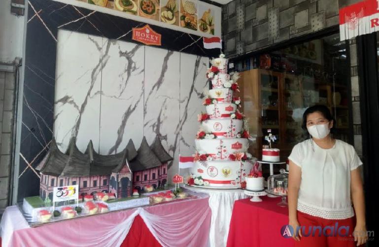 Owner Hokky Cake and Bakery berpose dengan kue rumah gadang dan aneka kue merah putih, Selasa (9/8). (Foto : Fajril)