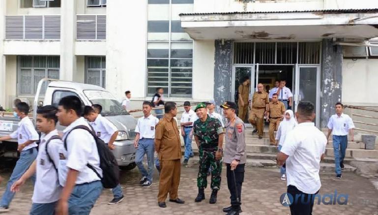 Anggota polisi bersama pihak sekolah saat lakukan penjagaan di salah satu sekolah, Senin siang (1/8). (Foto : Derizon)