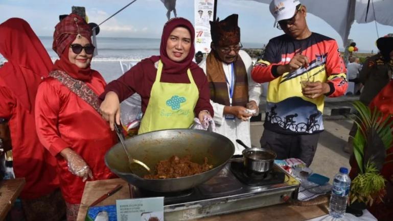 Wako Pariaman, Genius Umar dan istri ikut lomba memasak randang di sela kegiatan rakernas Apeksi di Padang, Selasa (9/8). (Dok : Istimewa)