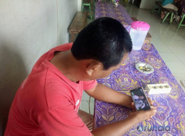 Warga Padang, Mulyadi, asik menonton Youtube. Hari ini, jaringan Telkomsel mengalami penurunan kualitas. (Foto : Fajril)