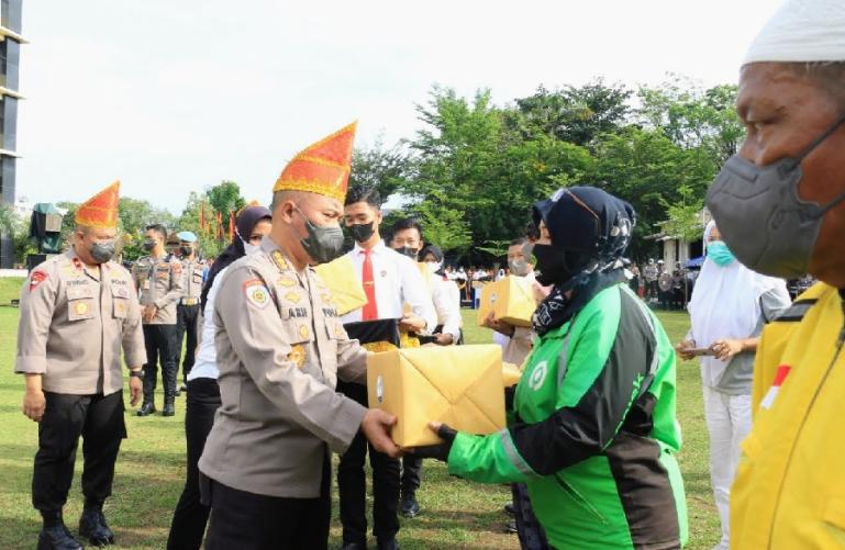 Kapolda Sumbar Irjen Pol Teddy Minahasa serahkan paket bansos kepada komunitas ojol di halaman Mapolda Sumbar, Rabu (21/9). (Dok : Istimewa)