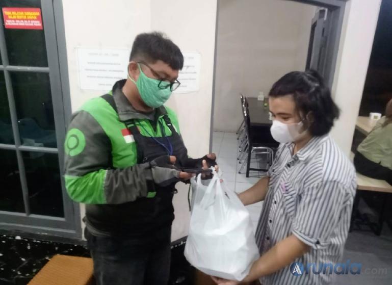 Mitra Gojek menerima bungkusan makanan yang dipesan dari karyawan Malabar Arham Jalan Mahakam kawasan GOR H Agus Salim Kota Padang, Sabtu (29/10). (Foto : Fajril)