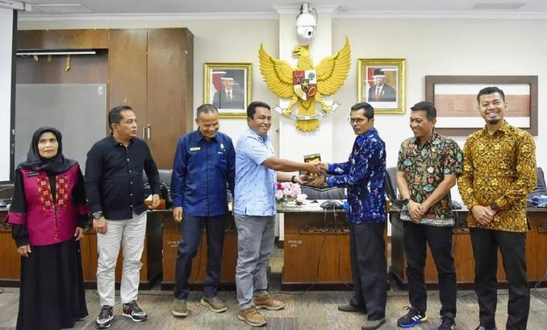 Sekretaris DPRD Sumbar Raflis serahkan cinderamata kepada rombongan DPRD Kabupaten Kepulauan Meranti, Jumat (14/10). (Dok : Istimewa)