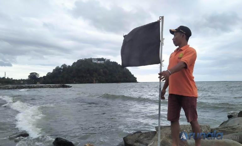 Seorang petugas Balawista Padang memasang bendera peringatan di kawasan Pantai Padang, Sabtu (19/11). (Foto : Derizon)