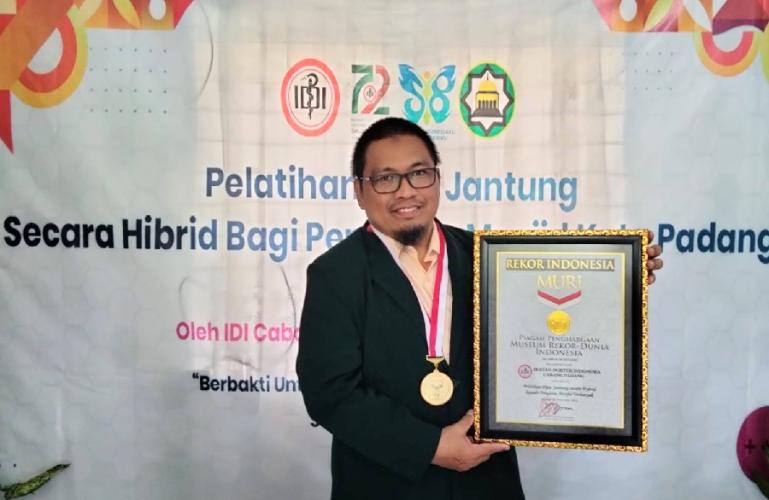 Ketua IDI cabang Padang dr Muhammad Riendra SpBTKV (K)-VE memperlihatkan piagam Rekor MURI, Minggu (20/11). (Dok : Istimewa)