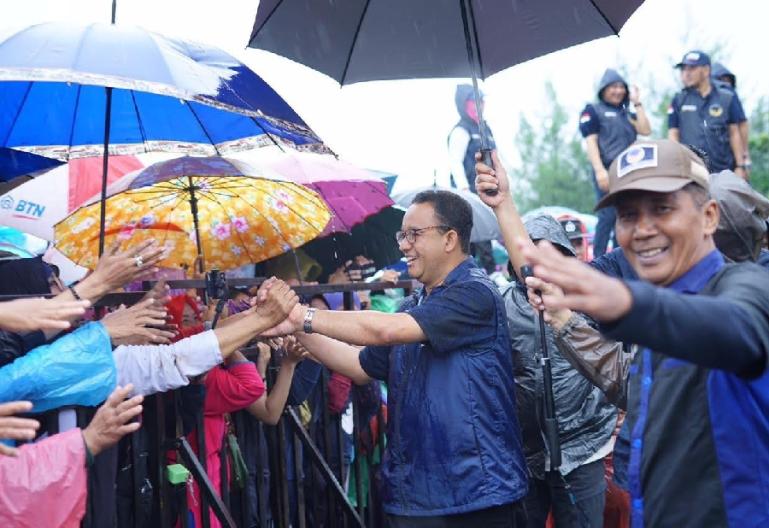 Bakal calon presiden NasDem Anies Baswedan menyapa pendukungnya dengan payung di tangan mereka. (Dok : Istimewa)
