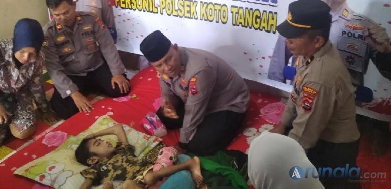 Kapolsek Koto Tangah, Kota Padang, AKP Afrino Chaniago bersama jajarannya saat membezuk Aditya di rumahnya di  di Simpang Anak Air, Senin (5/12). (Foto : Derizon)