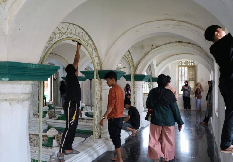 Mahasiswa UNP jurusan Sejarah yang KKN Tematik di Nagari Batuhampar sedang bersihkan situs wisata religis di nagari itu. (Dok : Istimewa)