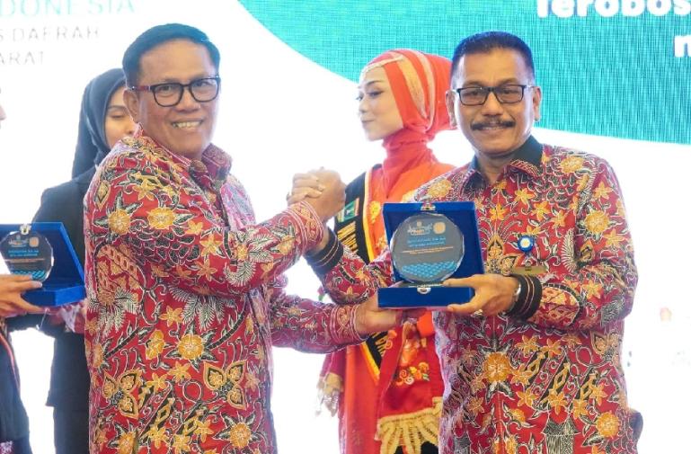 Dirut Bank Nagari, Muhamad Irsyad menerima cendera mata dari Ketua DPD REI Sumbar, Ardinal saat Rakerda DPD REI Sumbar ke-11 di Pangeran Beach Hotel Padang, Kamis (16/2). (Dok : Istimewa)