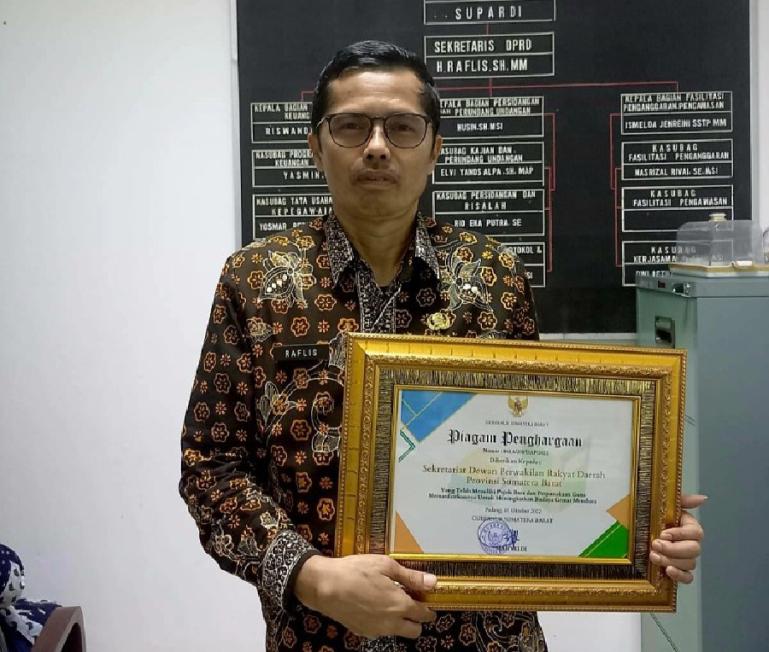 Sekretaris DPRD Sumbar, Raflis dengan piagam penghargaan Anugerah Keterbukaan Informasi Publik dari KI Sumbar. (Dok : Istimewa).