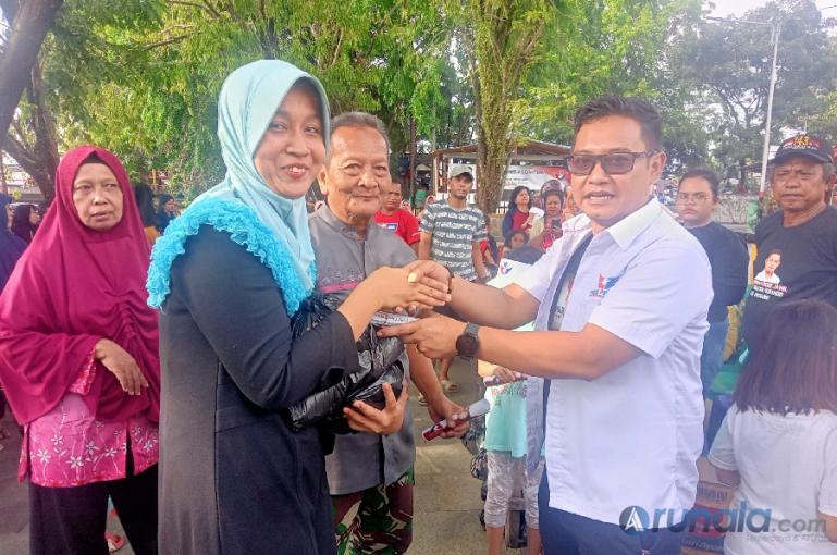 Salah seorang warga Seberang Padang Selatan menerima bantuan sembako dari Ketua DPD Perindo Kota Padang, Muhammad Imron Jamil, Minggu sore (19/3). (Foto : Arzil)