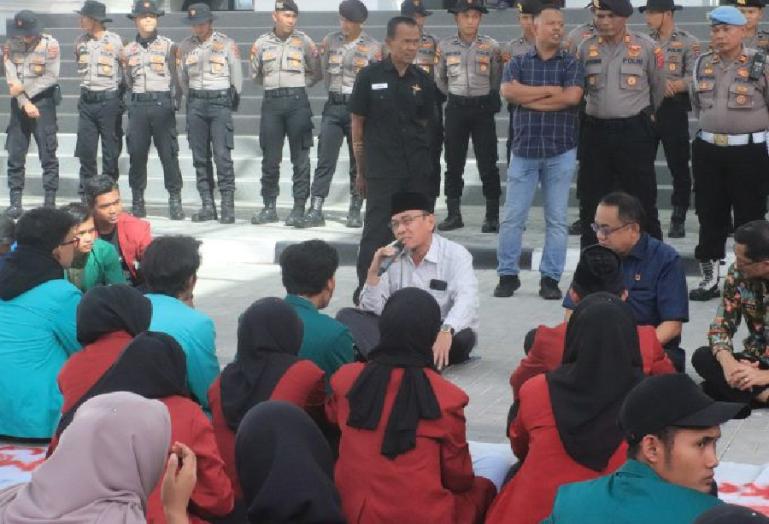 Dua anggota DPRD Sumbar yakni Maigus Nasir dan Ali Tanjung duduk bersama para mahasiswa di lantai teras depan kantor DPRD Sumbar saat aksi demo berlangsung, Kamis siang (6/4). (Dok : Istimewa)