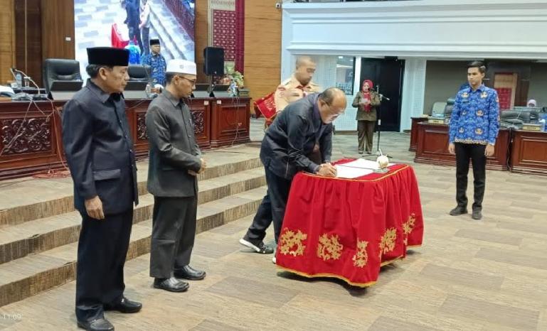 Ketua DPRD Sumbar Supardi, disaksikan Wagub Audy Joinaldy dan para pimpinan dewan tanda tangani naskah pengesahan dua Ranperda menjadi Perda di sidang paripurna, Rabu (17/5). (Dok : Istimewa)
