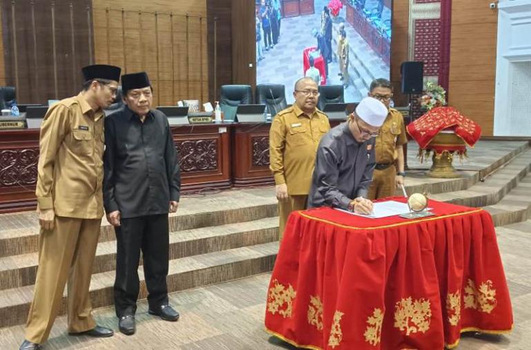 Wakil ketua DPRD Sumbar Irsyad Syafar teken berita acara pengesahan Perda Pajak dan Retribusi Daerah, Selasa (20/6). (Dok : Istimewa)