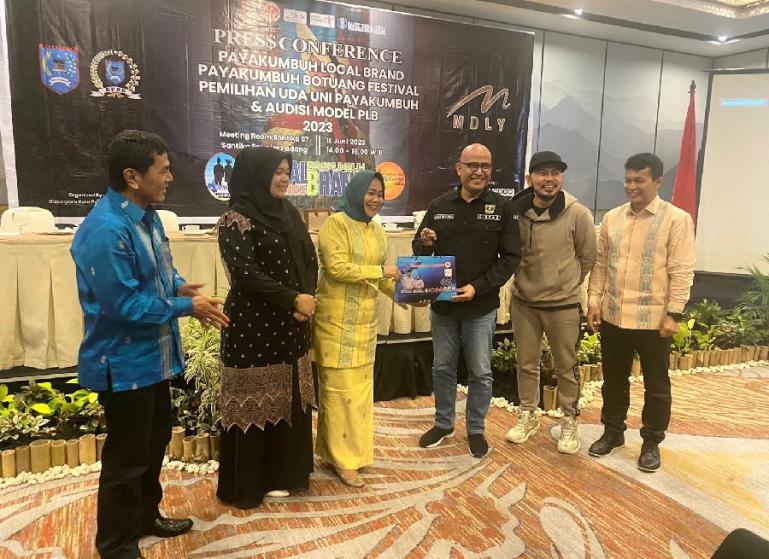 Ketua Dekranasda Kota Payakumbuh Elfriza Zaharman menyerahkan cinderamata kepada Kadis Pariwisata Sumbar Luhur Budianda saat Konferensi Pers di Hotel Santika Premiere Padang, Minggu (11/6). (Dok : Istimewa)