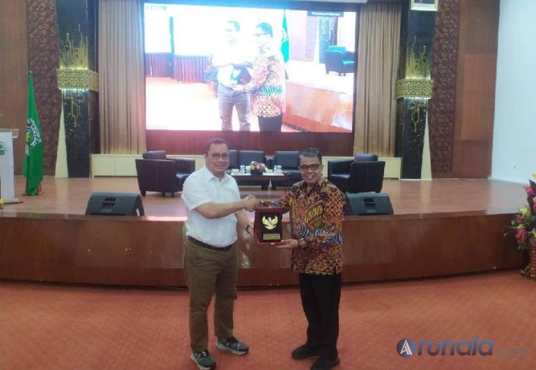Rektor Unand Prof Dr Yuliandri SH MH menerima cenderamata dari Sekretaris Satgas Percepatan Sosialisasi UU Cipta Kerja Arif Budimanta saat Workshop Peran dan Manfaat UU Cipta Kerja Bagi Generasi Muda di Convention Hall Unand, Selasa (27/6). (Foto : Fajril