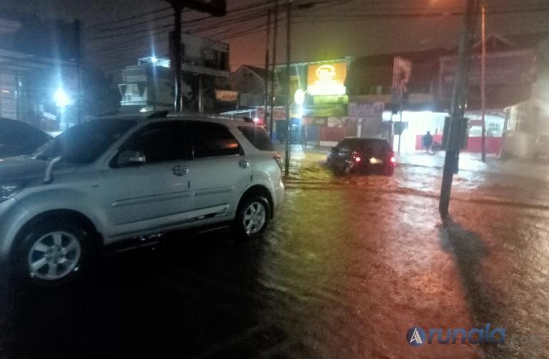 Terlihat sebuah mobil menerabas genangan air yang membanjiri Jalan Joni Anwar Lapai, Padang, Jumat (14/6) dini hari. (Foto : Arzil)