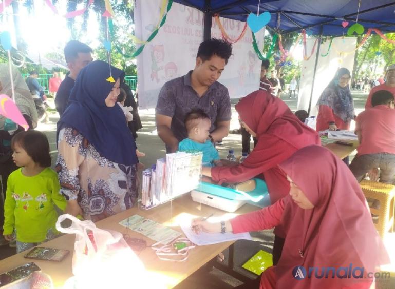 Sepasang suami istri menimbang berat badan bayinya di stan Departemen IKA FK Unand/RSUP Dr M Djamil-IDAI Sumbar saat Car Free Day, Minggu (23/7). (Foto : Fajril)