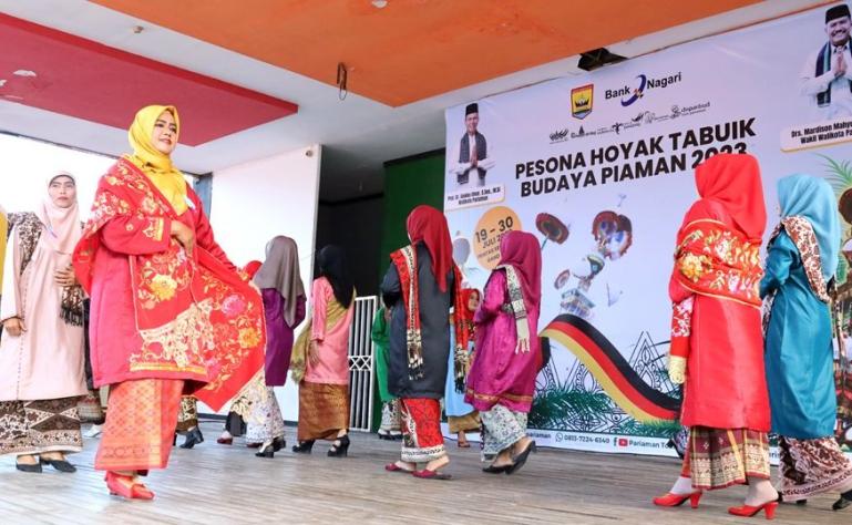 Para guru PAUD berjalan di atas panggung memakai baju kuruang basiba pada lomba yang diadakan Dispas Kota Pariaman, Rabu (26/7). (Dok : Istimewa)