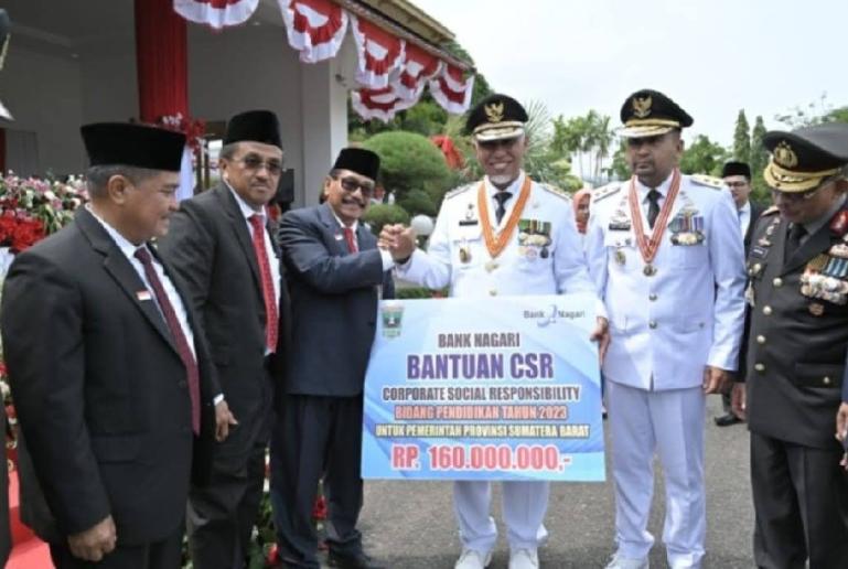 Direktur Utama Bank Nagari M Irsyad menyerahkan CSR Pendidikan ke Gubernur Sumbar Mahyeldi Ansharullah usai Upacara HUT ke-78 Kemerdekaan RI, di Halaman Istana Gubernuran Sumatera Barat, Kamis (17/8). (Dok : Istimewa)
