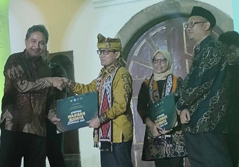 Kepala Dinas Kebudayaan Sumbar, Syaifullah menerima sertifikat penghargaan WBTbI dari Kemenristek Dikti, kemarin. (Dok : Istimewa)