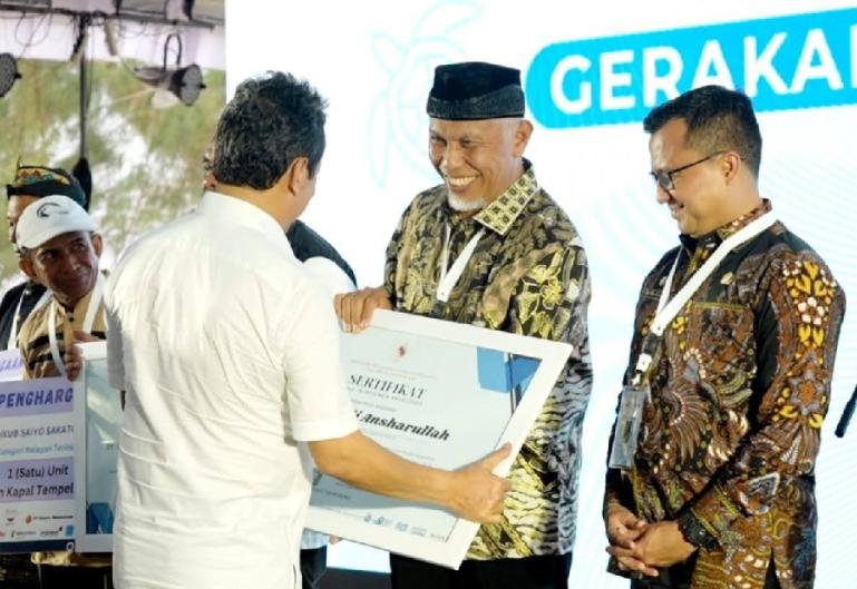 Gubernur Sumbar, Mahyeldi Ansharullah menerima penghargaan dari Menteri KKP, Sakti Wahyu Trenggono saat acara puncak apresiasi Gerakan Nasional Bulan Cinta Laut (BCL) di Pantai Kenjeran, Surabaya, Jumat (10/11). (Dok : Istimewa)