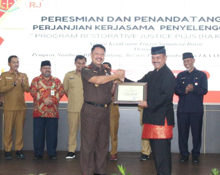 Ketua LKAAM Sumbar, Dr Fauzi Bahar MSi Datuak Nan Sati menerima piagam  penghargaan Restorative Justice dari Kepala Kejaksaan Tinggi Sumbar, Asnawi, Senin (20/11). (Foto : Arzil)