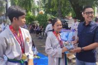 Pembina Dojang Sisinga Fighter, Rachmat Wijaya memberikan apresiasi kepada Gibran dan Asha dan Atar karena meraih medali di Kejurda Taekwondo Kota Solok, Minggu (10/12). (Dok : Istimewa)