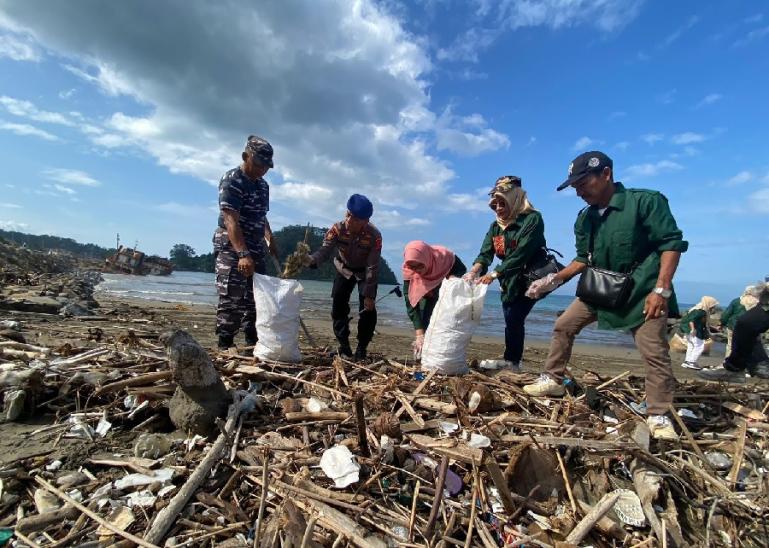 Kadis DKP Sumbar Dr Ir Reti Wafda MTp bersama Lantamal II dan Pol Airud memungut sampah saat Aksi Bersih Pantai di kawasan Pantau Padang, Rabu (27/12). (Dok : Istimewa)
